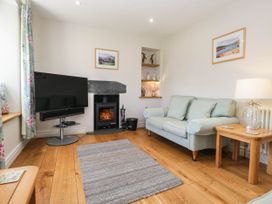 A living room with a television and fireplace at Cragg Cottage in Coniston