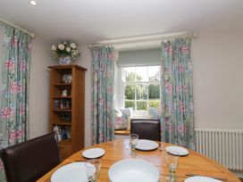 A dining room with a table set for meals at Cragg Cottage in Coniston