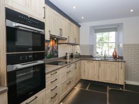 A kitchen with appliances and a window at Cragg Cottage in Coniston