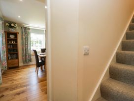 A dining room with a staircase and light switch at Cragg Cottage in Coniston