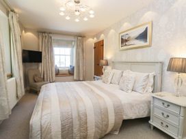 A bedroom with a bed and television at Cragg Cottage in Coniston