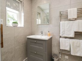 A bathroom with a sink and mirror at Cragg Cottage in Coniston