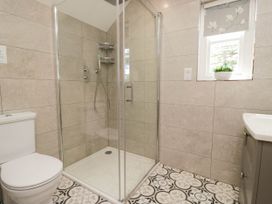 A bathroom featuring a shower, toilet, and sink at Cragg Cottage in Coniston