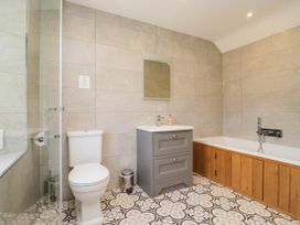 A bathroom with a bathtub, sink, and toilet at Cragg Cottage in Coniston