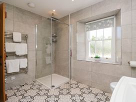 A bathroom with a shower and towel rack at Cragg Cottage in Coniston