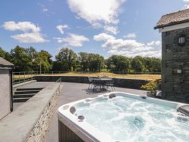 An outdoor area with a hot tub and seating at Cragg Cottage in Coniston