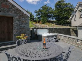 An outdoor patio with a table and chairs at Cragg Cottage in Coniston