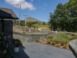 An outdoor area with a stone wall and mountain view at Cragg Cottage in Coniston