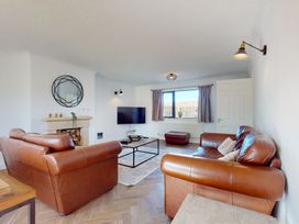 A living room with a sofa and television at Low Greenlands House in Tewitfield
