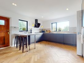 A kitchen with an island and stools at Low Greenlands House Tewitfield