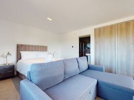 A bedroom with a bed, sofa, and wardrobe at Low Greenlands House in Tewitfield