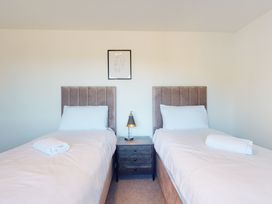 A bedroom with two single beds and a nightstand at Low Greenlands House in Tewitfield