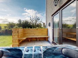An outdoor area with a hot tub and wooden seating at Low Greenlands House Tewitfield