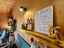 A living room with a shelf displaying rabbits and wall art at Harriet in Llangurig
