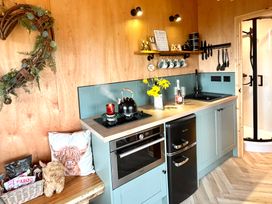 A kitchen with a kettle and flowers at Harriet in Llangurig