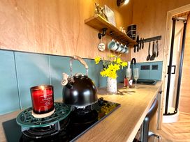 A kitchen with a kettle and flowers on the counter at Harriet in Llangurig