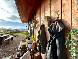 An outdoor area with coats hanging and a table at Harriet in Llangurig