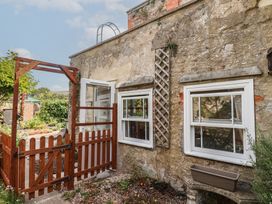 An outdoor area with a wooden gate and windows at Garden Studio at Stanley House in Charmouth