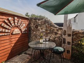 An outdoor area with a table set, wine bottle, and glasses at Garden Studio at Stanley House in Charmouth
