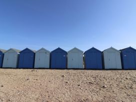 A row of blue beach huts at the beach at Garden Studio at Stanley House Charmouth