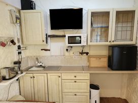 A kitchen with sink, microwave, and cabinets at Garden Studio at Stanley House Charmouth