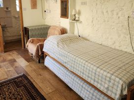 A bedroom with a bed and chair at Garden Studio at Stanley House in Charmouth