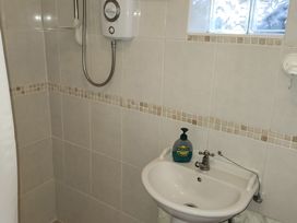 A bathroom with a sink and shower at Garden Studio at Stanley House Charmouth