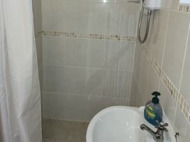 A shower area with a sink and soap dispenser at Garden Studio at Stanley House, Charmouth