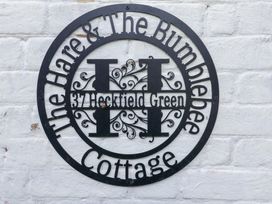 A sign displaying the name and address at The Hare & the Bumblebee Cottage in 37 Heckfield Green