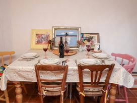 A dining room table set with plates and glasses at The Hare & the Bumblebee Cottage