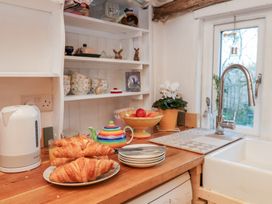 A kitchen with croissants on a plate and a fruit bowl at The Hare & the Bumblebee Cottage