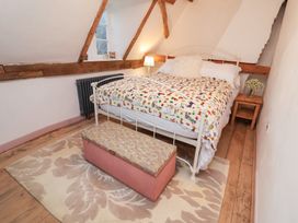 A bedroom with a bed and bedside table at The Hare & the Bumblebee Cottage