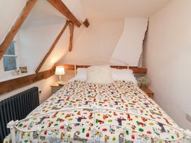 A bedroom with a bed and wooden beams at The Hare & the Bumblebee Cottage