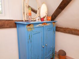 A blue cabinet with a mirror and decorative items at The Hare & the Bumblebee Cottage