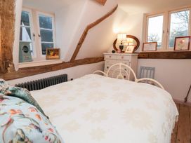 A bedroom with a bed and decorative items at The Hare & the Bumblebee Cottage