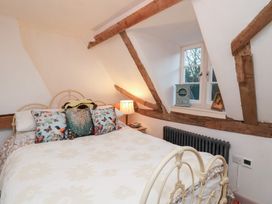 A bedroom with a bed and window at The Hare & the Bumblebee Cottage