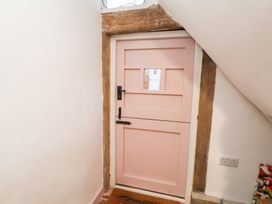 A pink door with a window in an entryway at The Hare & the Bumblebee Cottage