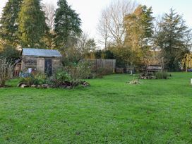 A garden with a shed and trees at The Hare & the Bumblebee Cottage