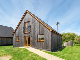 A house with wooden exterior and balcony at Aspen Lodge Near Brigg