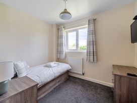 A bedroom with a single bed and a television at Aspen Lodge Near Brigg