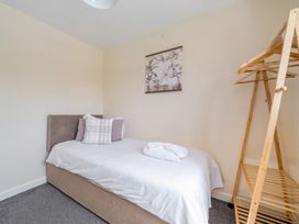 A bedroom with a single bed and a clothes rack at Aspen Lodge Near Brigg