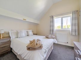 A bedroom with a bed and window at Aspen Lodge near Brigg