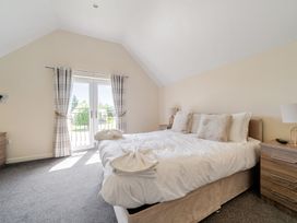 A bedroom with a bed and nightstands at Aspen Lodge Near Brigg