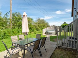 A garden with a table and chairs beside a hot tub at Aspen Lodge Near Brigg