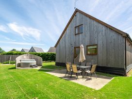 A house with a hot tub and patio furniture at Aspen Lodge near Brigg