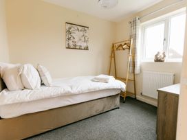 A bedroom with a bed and a clothing rack at Sage Lodge in Brigg