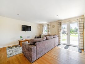 A living room with a sofa and television at Sage Lodge near Brigg