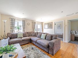 A living room with a sofa, windows, and curtains at Sage Lodge near Brigg