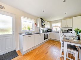 A kitchen with a dining table and appliances at Sage Lodge Near Brigg