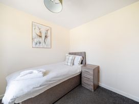 A bedroom with a single bed and bedside table at Sage Lodge near Brigg